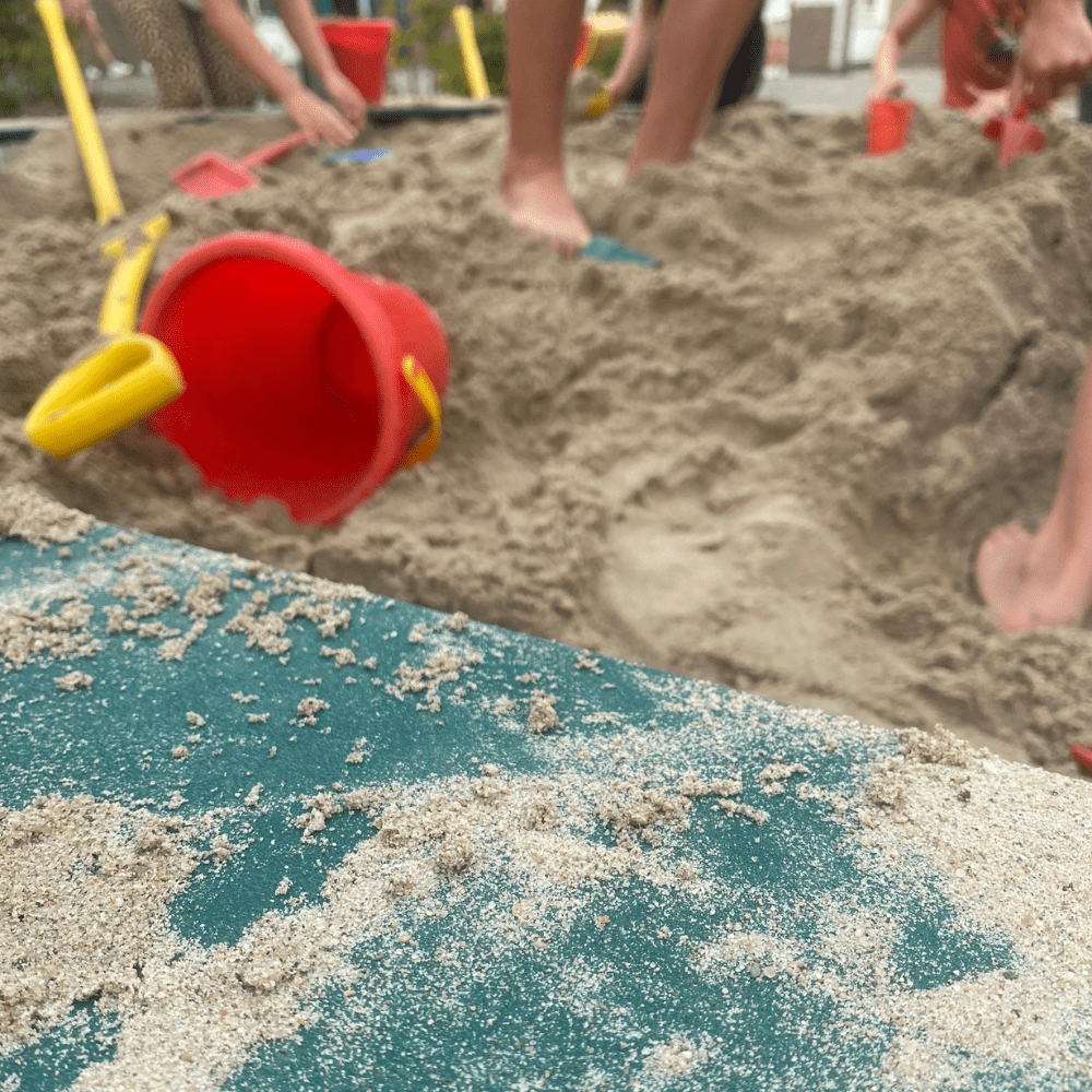 spelen met zand in beton zandbak bij OBS De Tovertoren in Hoofddorp